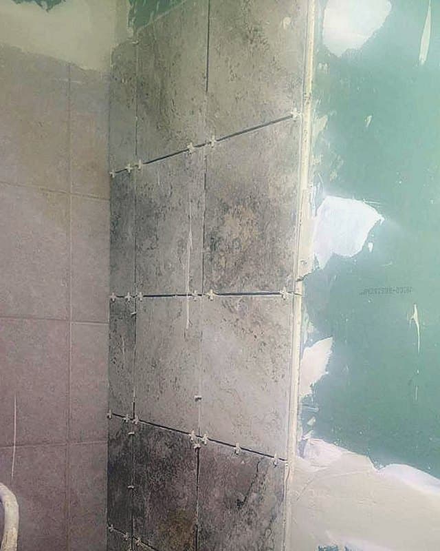 After: The tile completed up the wall, shown before grout